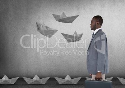 Businessman with briefcase and paper boats