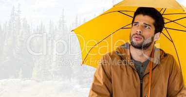 Man with yellow umbrella in bright forest