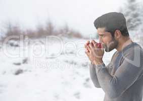 Man drinking from cup in snow landscape