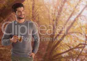 Man in Autumn with cup in forest