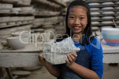 Portrait of happy girl holding clay