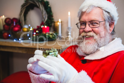Santa claus holding a gift at home Santa claus holding a gift at home