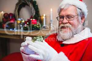 Santa claus holding a gift at home