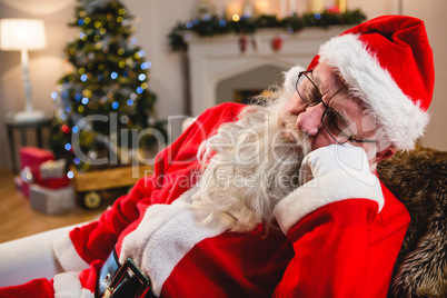 Santa claus relaxing on sofa in living room at home