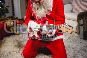 Attentive santa claus playing a guitar