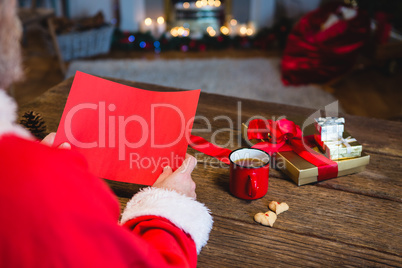 Santa Claus holding blank red paper