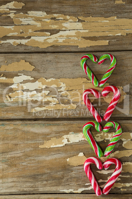 Multicolored candy canes arranged on wooden plank