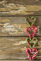 Multicolored candy canes arranged on wooden plank