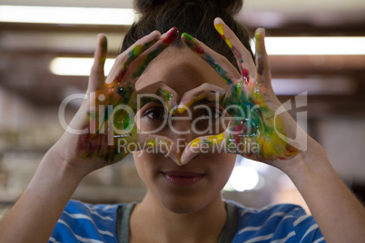 Female potter gesturing with painted hands