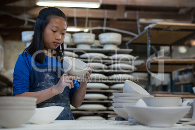 Attentive girl checking bowl at worktop