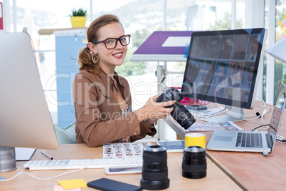 Female executive reviewing captured photograph at her desk in office