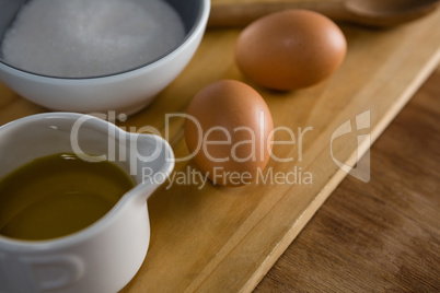 Brown eggs and sugar on chopping board