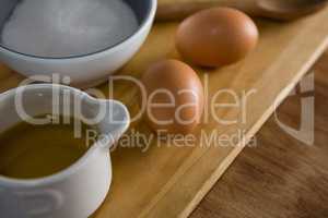 Brown eggs and sugar on chopping board
