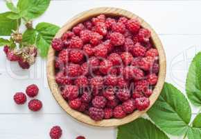 ripe red raspberries in a wooden bowl