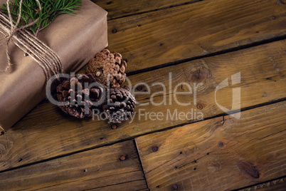 Gift box, fir and pine cone on wooden table