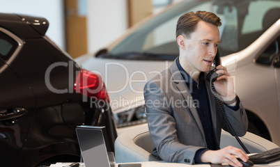 Businessman talking on landline phone in showroom