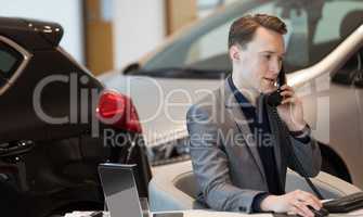 Businessman talking on landline phone in showroom