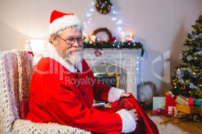 Santa Claus putting presents in christmas bag