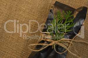 Close up of packet and pine twig tied with rope