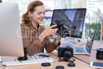 Female executive reviewing captured photograph at her desk