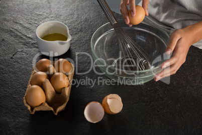 Woman breaking eggs into a bowl