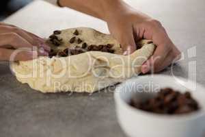 Woman kneading dough with chocolate chips