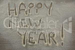 The word happy new year written on sprinkled flour