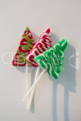Christmas tree lollipops on white background