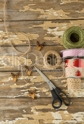 Ribbon roll, scissors and jute rope on wooden table