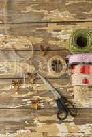 Ribbon roll, scissors and jute rope on wooden table