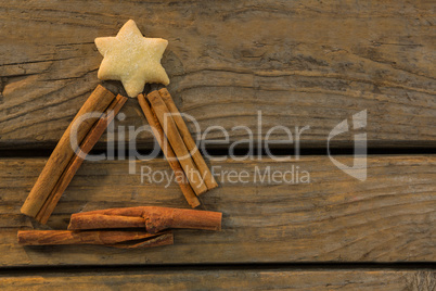 Overhead view of star shape cookie with cinnamon sticks