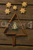 Overhead view of star shape cookies by Christmas tree made with cinnamon stick