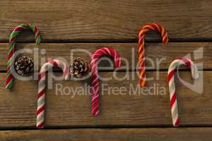Overhead view of colorful candy canes with pine cones