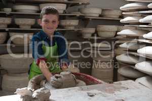 Boy making a pot in pottery workshop