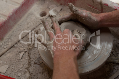 Male potters hand making a pot