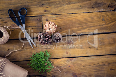 Fir, pine cone and wrapping materials on wooden table