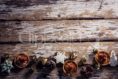 Cookies and christmas decoration arranged on wooden plank