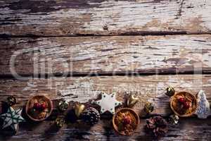 Cookies and christmas decoration arranged on wooden plank