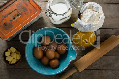 Brown eggs and ingredients on wooden plank