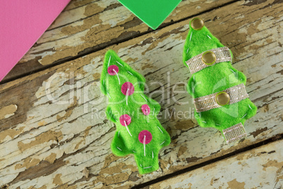 Handmade christmas trees and craft material on wooden plank