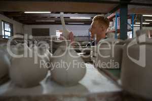 Male potter examining a earthenware equipment