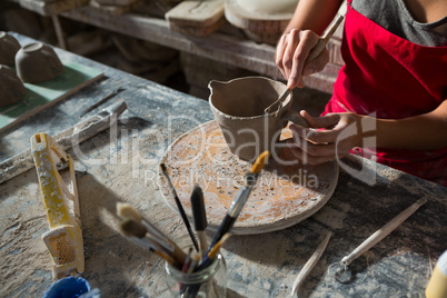 Female potter carving mug