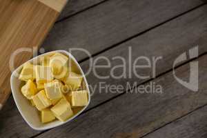 Cheese cubes in a bowl on wooden table