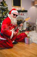 Smiling santa claus playing a guitar