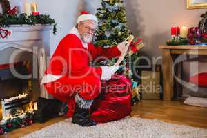 Santa Claus reading scroll in living room