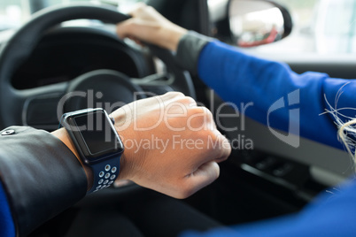 Cropped image of woman wearing wristwatch in car