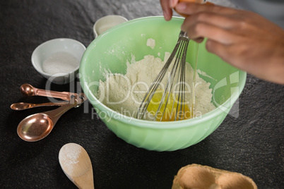 Woman whisking flour in bowl