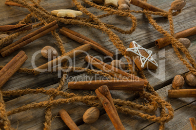 Close up of rope with star shape cookies and cinnamon sticks by walnuts