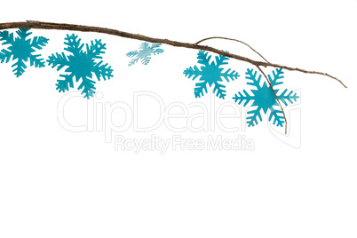 Snowflakes decorated on branch against white background