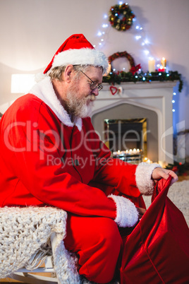 Santa Claus putting presents in christmas bag